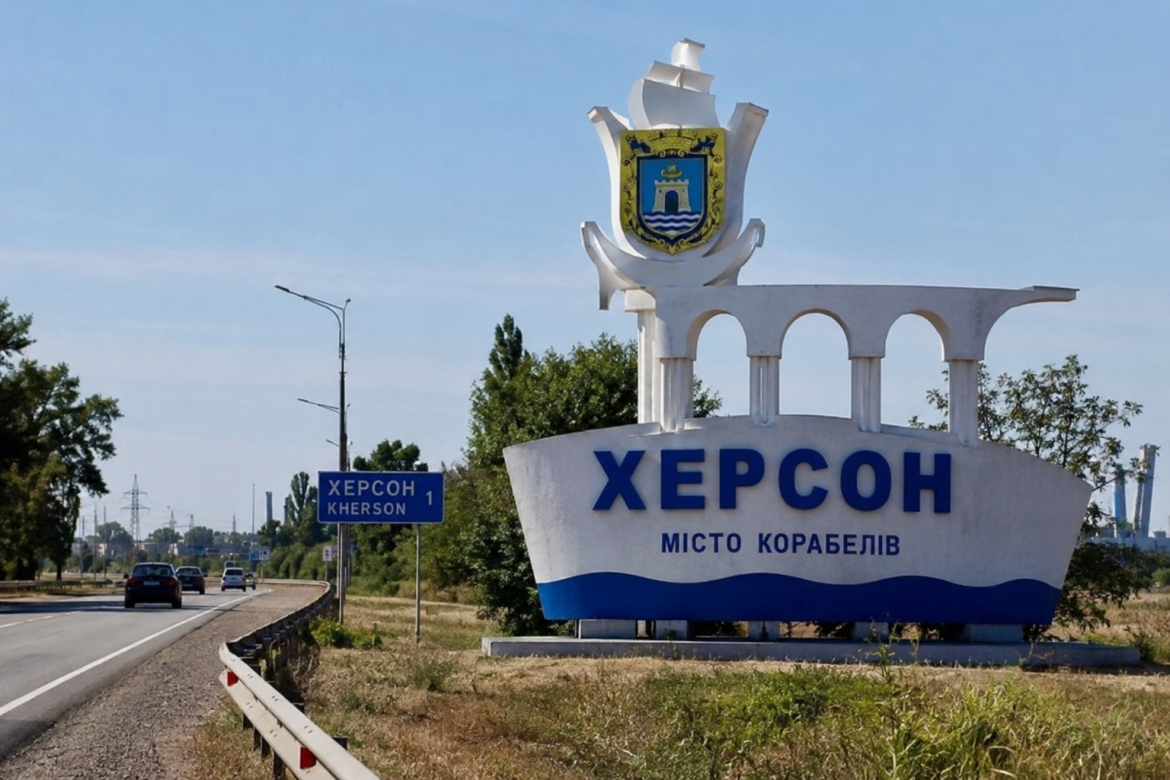 В'їзна стела міста Херсон із гербом міста біля автомобільної дороги.